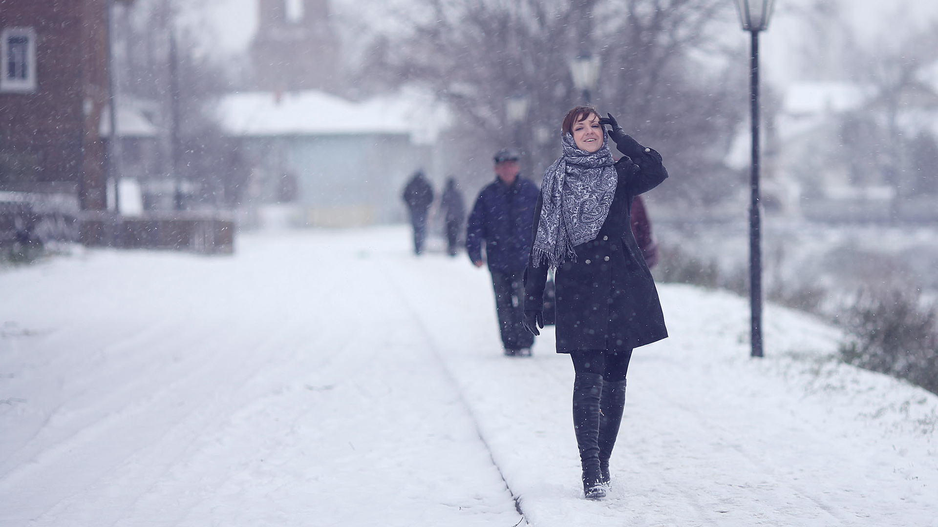 Nainen kävelemässä lumipyryssä talvella